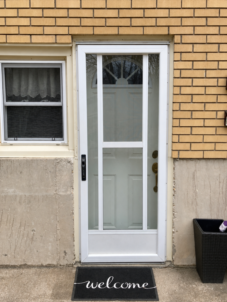 Storm door replacement installed in a brick exterior opening.